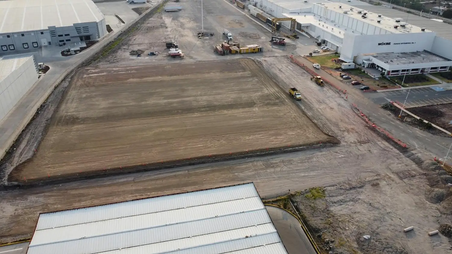 Vista aérea de plataforma conformada y compactada entre naves de un parque industrial